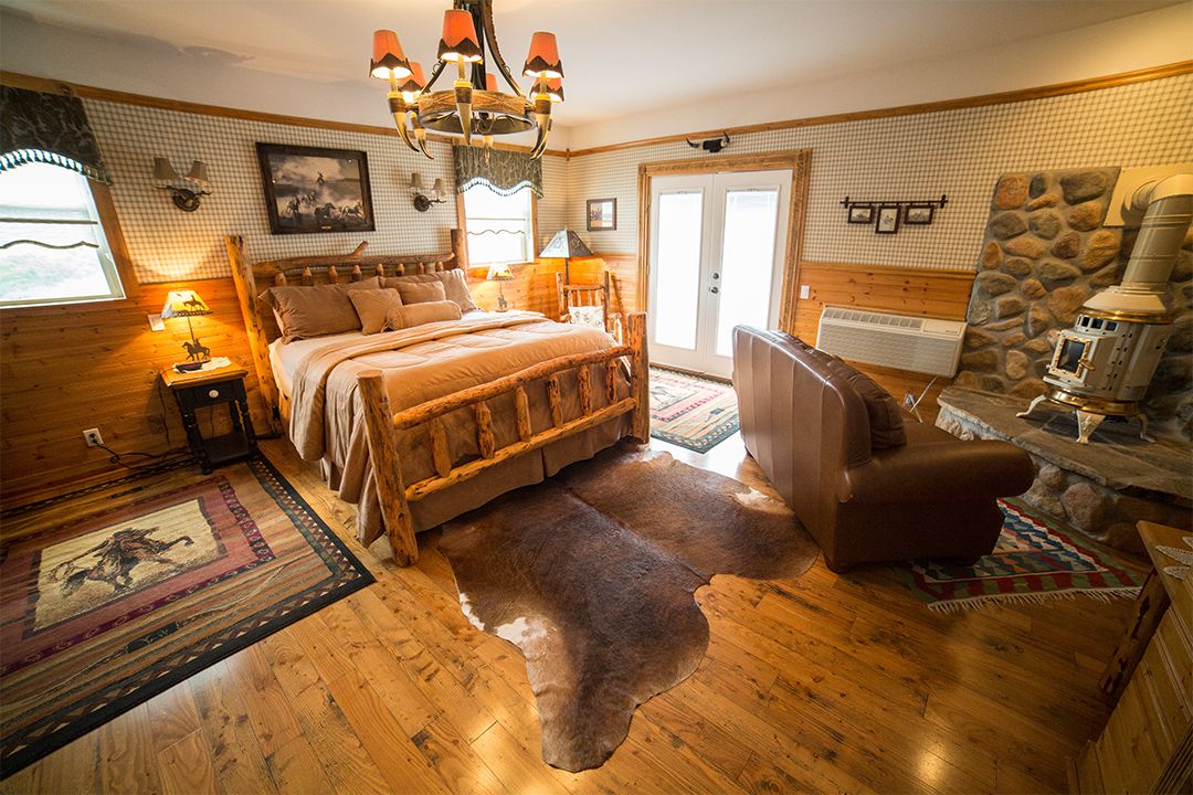 A Lodgepole Bed, A Potbelly Stove, and A horn Chandelier - Only in Our Buttonwood Room
